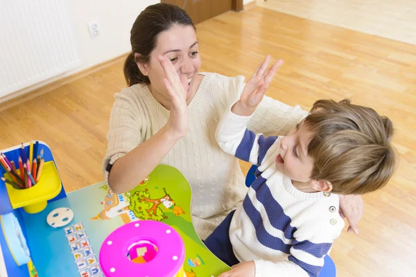 Mutter spielt mit ihrem Kind und ermutigt es — Stockfoto