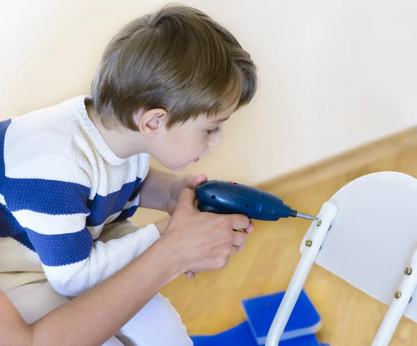 Petit garçon utilisant un outil bricolage aidé par un parent — Photo