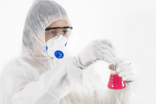 Mujer joven con traje protector sosteniendo algunos artículos de vidrio de laboratorio — Foto de Stock