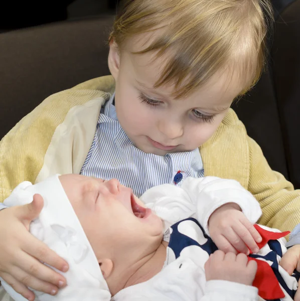 Neugieriger Junge hält seinen kleinen Bruder — Stockfoto