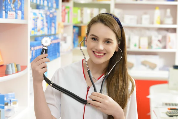 Jovem farmacêutica segurando um estetoscópio — Fotografia de Stock