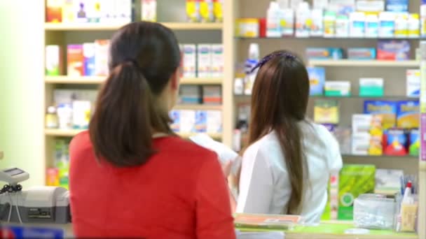 Клиент в аптеке покупает лекарства — стоковое видео