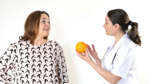 Médico aconsejando a una mujer gorda a comer sano — Vídeos de Stock