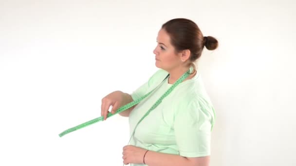 Grosse femme enveloppant un ruban à mesurer autour du cou 