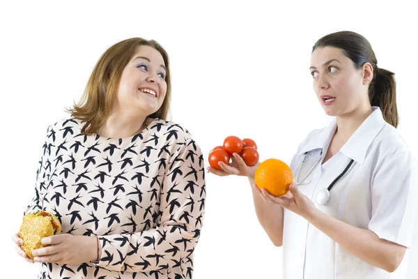 Doutor aconselhando uma mulher corpulenta para comer saudável Imagens Royalty-Free