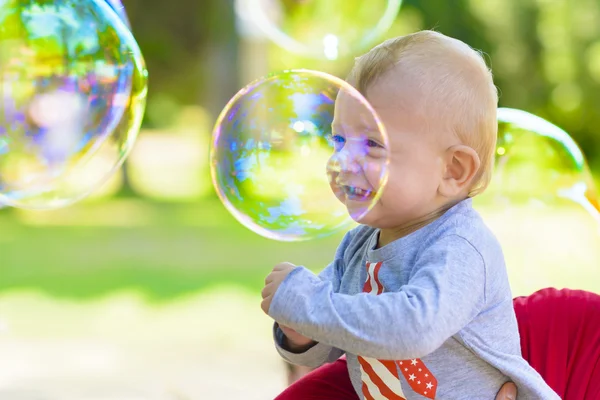 Niedliches Baby fängt Seifenblasen — Stockfoto