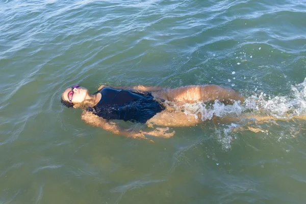 Mädchen schwimmt im Meer — Stockfoto