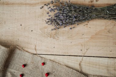 Kahverengi ahşap bir masada mis kokulu lavanta ve kırmızı böğürtlen.