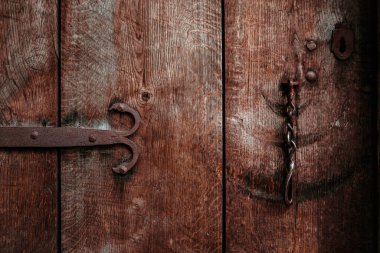 Antika ahşap, koyu kahverengi kapılı, metal desenli.