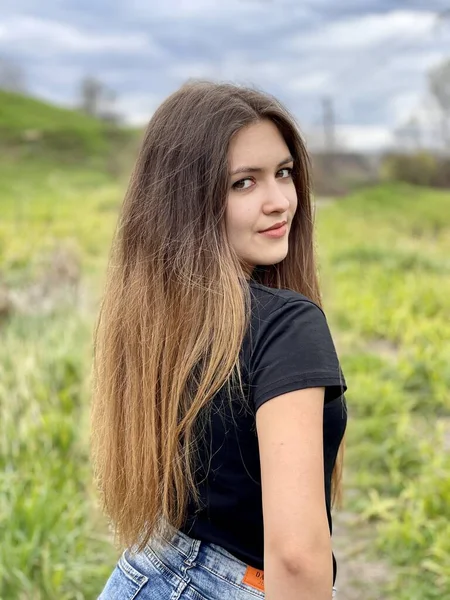 Tarlada fotoğraf çektirmek için poz veren güzel bir kız.