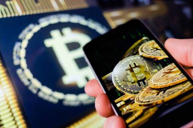 Cep telefonu tutan adam, bitcoin simgesi, borsa arkaplanı grafikli blok zinciri, kripto para birimleri veya bitcoin konsepti