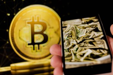 Cep telefonu tutan adam, bitcoin simgesi, borsa arkaplanı grafikli blok zinciri, kripto para birimleri veya bitcoin konsepti