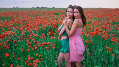 Haşhaş tarlasında yürüyen Avrupa görünümlü güzel bir kızın yakın plan portresi, doğal güzellik. Doğanın tadını çıkarıyor, iyi vakit geçiriyor..