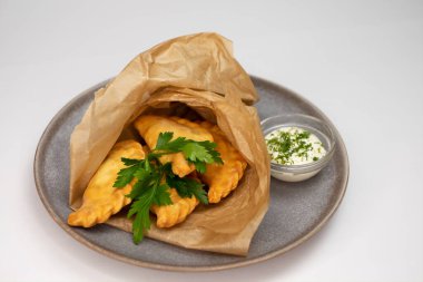 Beyaz arka planda et ve sebzeli şık bir yemek.