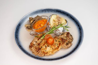 Beyaz arka planda et ve sebzeli şık bir yemek.