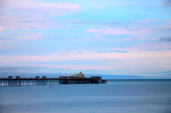 Paisagem costeira com cais, Inglaterra, Reino Unido. Paisagem minimalista à beira-mar com o cais, pôr do sol ou nascer do sol em cores pastel. — Fotografia de Stock