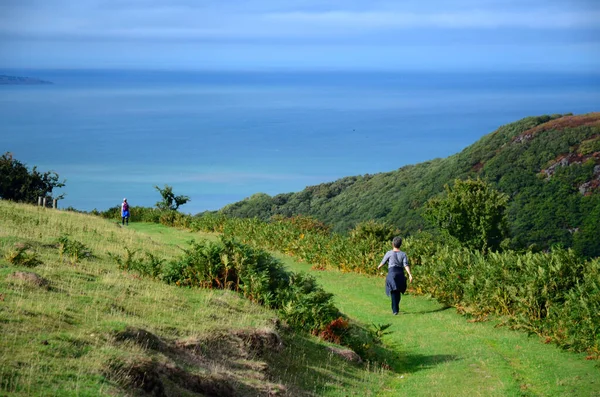 Hikers walking in the valley in Scotland, hiking path, sunny day. Active female hikers walking away. — 스톡 사진