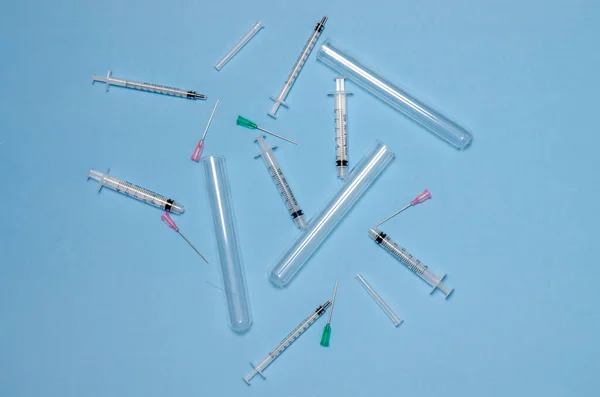 Vakcína. Injekční stříkačky, zkumavky a jehly na modrém pozadí. Koncept medicíny. Lékařské laboratorní vybavení. — Stock fotografie