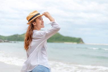 Kumsalda güneş şapkalı gülümseyen genç kadın. yaz, tatiller, tatil, seyahat kavramı