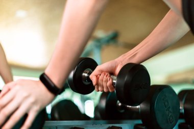 Kadınlar, spor salonunda dambıl kaldırarak egzersiz yaparlar. Spor salonunda spor yapan kadınlar..