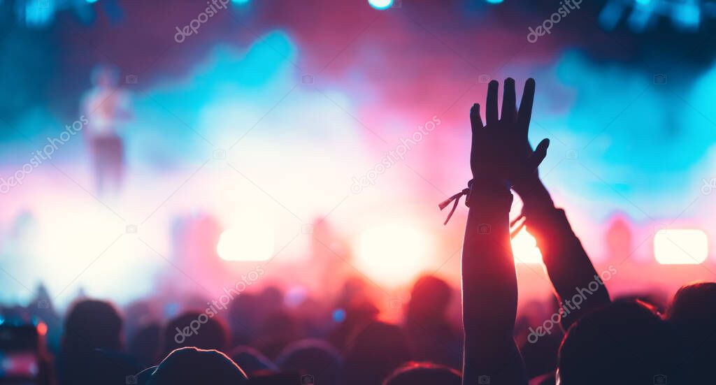 crowd with raised hands at concert festival