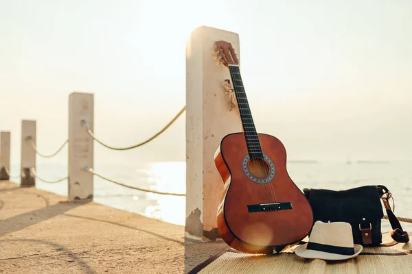 Капелюх Сумка Гітара Тростині Біля Моря Під Час Заходу Сонця — стокове фото