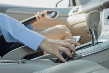 Arabadaki iş kadını çalışmak için cep telefonu yakalıyor..