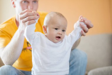 Mutlu baba evdeki odada sevimli bebekle oynuyor..