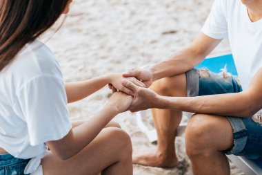 Sabahları plajda el ele tutuşan iki aşık. Yeni evli çift romantik bir tatile çıktı.