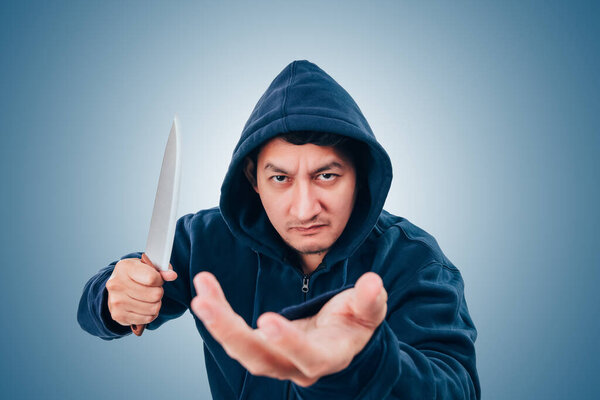 Грабитель, бандит или вор держат нож на черном фоне. 