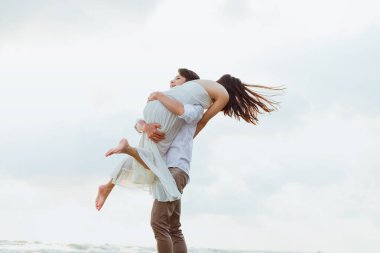 Romantik çift yazın sahilde birbirlerine sarılırlar. Balayı, seyahat, tatil, yaz konsepti. 