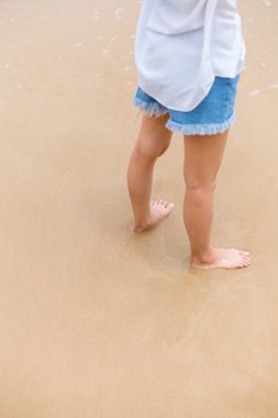 Kumsalda yürüyen mutlu genç kız. Yaz seyahati, meslek, tatil konsepti.