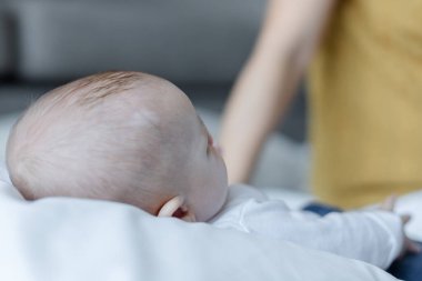 Mutlu anne ve bebek evdeki yatakta birlikte oynuyorlar. Aile sevgisi kavramı.