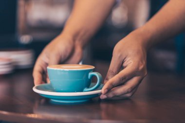 Barista kahve dükkanında müşteriye kahve servisi yapıyor..