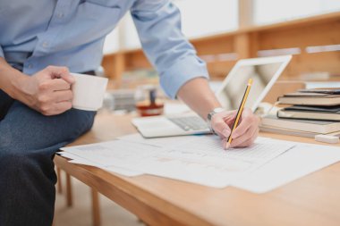 Bütçe muhasebesini hesaplamak için kalem kontrolü veri hesap makinesi kullanan bir işadamı. finans ve muhasebe kavramı