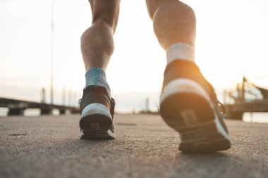 Gün batımında yolda koşan adam..