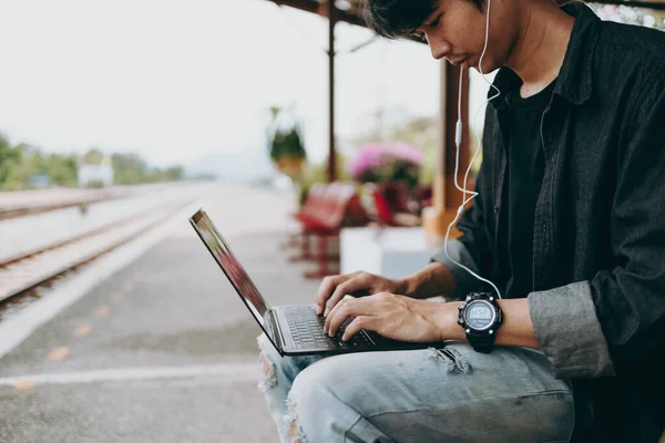 Egy Fiatal Ázsiai Férfi Laptopot Használ Vasútállomáson Való Utazáshoz Kereséshez — Stock Fotó