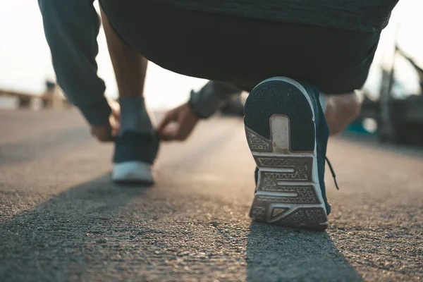 closeup of shoe laces on the road before running in sunset. Sport and workout concept.