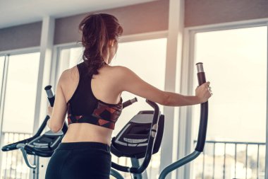 Spor salonunda eliptik antrenör kullanan genç kadınlar..