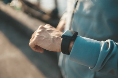 Spor adamı antrenman sırasında ve parkta koşarken Akıllı Saati kontrol ediyor.. 