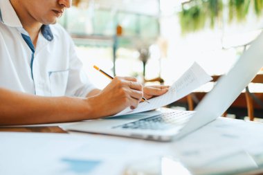 Yönetici işadamı rapor hazırlıyor, dengeyi hesaplıyor. Masadaki gelir tabloları, grafikleri ve verileri analiz etme işi.