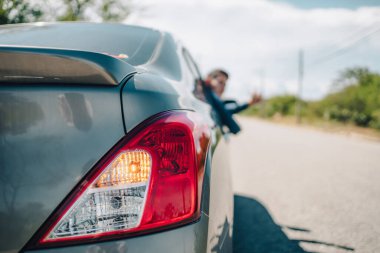 Acil durum ışıkları, yolda kırık bir arabanın stop lambaları ve el işareti vererek arabanın camını fırlatın..