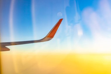 Sabahın köründe bulutların üzerinde uçan bir uçak. Seyahat ve ulaşım kavramı. 