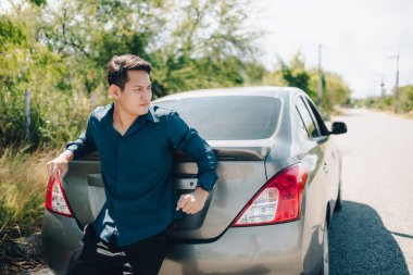 Sıcak bir günde yolda bozuk bir arabayı iten adam. Araba arızası.