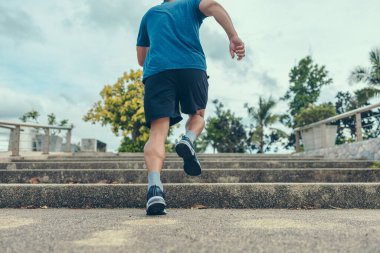 Gün batımında merdivenlerden çıkan adam..