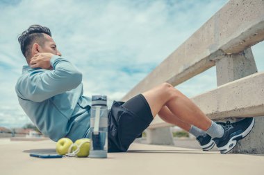 Genç adam yerde abdominal egzersizler yapıyor. Spor, spor ve parkta eğitim..