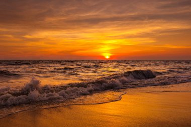 Sahilde gün doğumu, gün batımı ve tropikal bir denizde okyanus dalgaları.. 