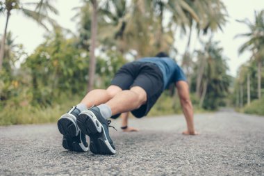 Parkta şınav çeken genç bir sporcu. Fitness, antrenman, egzersiz konsepti.