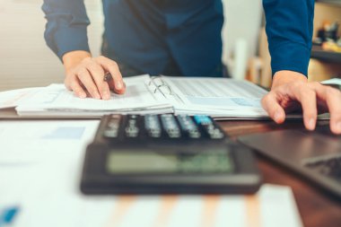 Ofis masasındaki veri tablosuyla muhasebe işi. Hesap özeti ve hesap özeti olan hesap makinesi..