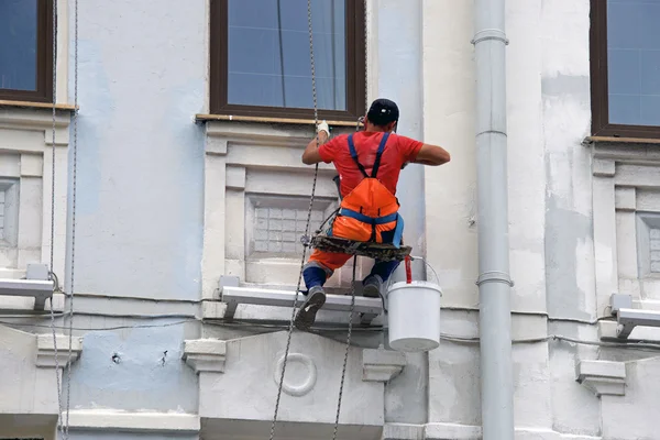 Builder arbetare målning fasad höghusbyggnad med rolle — Stockfoto